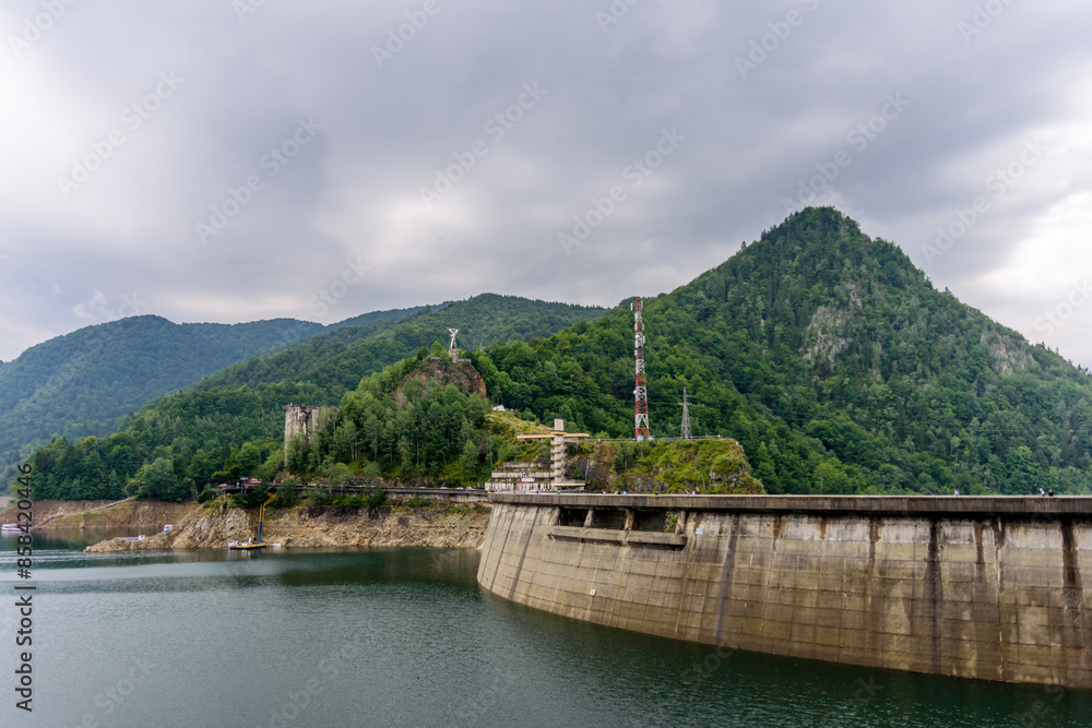 Scenic view of Vidraru Dam and the surrounding areas under a cloudy sky in Romania Scenic view of Vidraru Dam and the surrounding areas under a cloudy sky in Romania