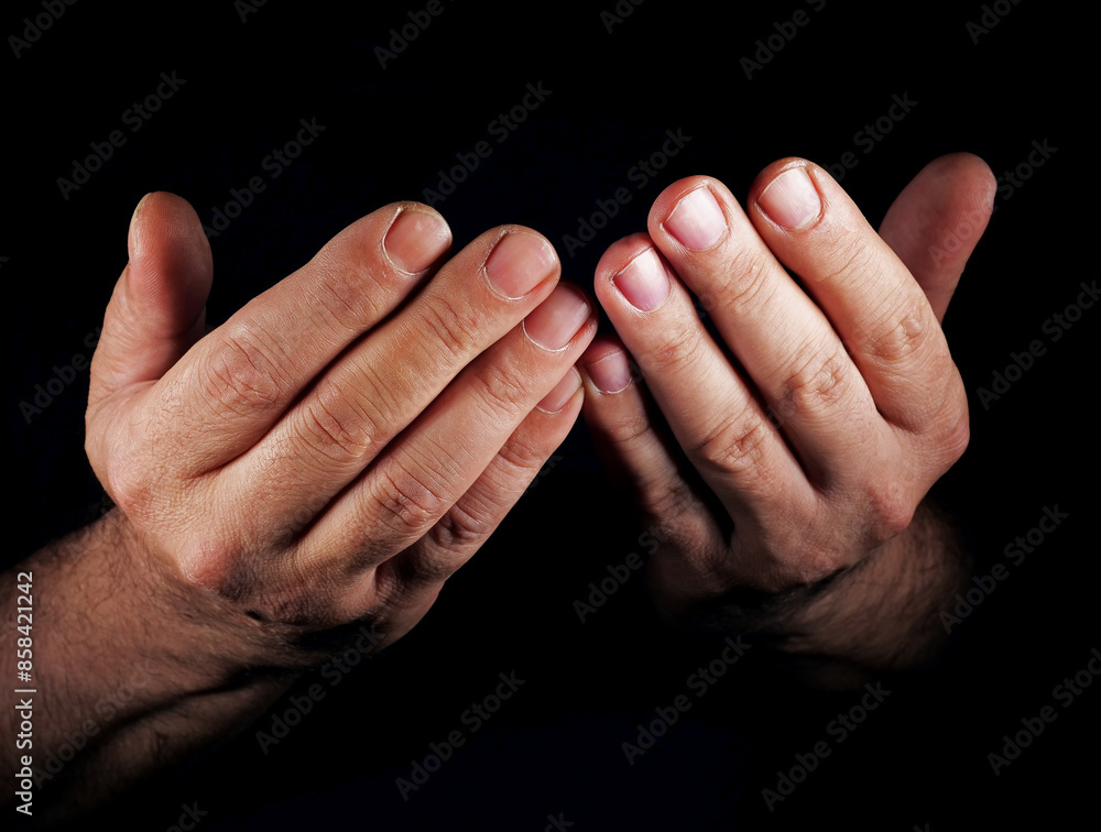Fototapeta premium praying hands of a muslim person on black background