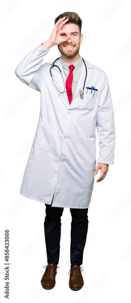 Young handsome doctor man wearing medical coat doing ok gesture with hand smiling, eye looking through fingers with happy face. Young handsome doctor man wearing medical coat doing ok gesture with hand smiling, eye looking through fingers with happy face.