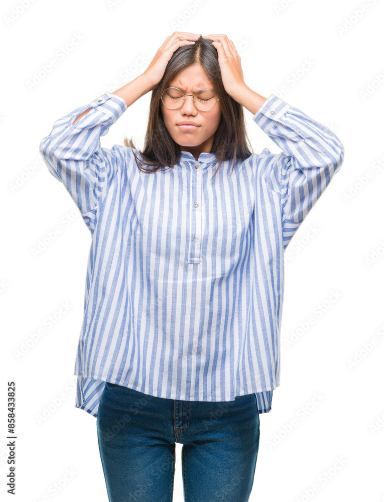Young asian woman over isolated background suffering from headache desperate and stressed because pain and migraine. Hands on head. Young asian woman over isolated background suffering from headache desperate and stressed because pain and migraine. Hands on head.