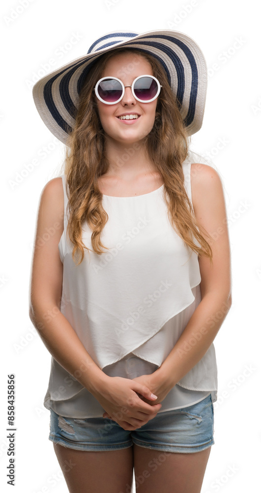 Young blonde woman wearing sunglasses and summer hat with a happy face standing and smiling with a confident smile showing teeth Young blonde woman wearing sunglasses and summer hat with a happy face standing and smiling with a confident smile showing teeth