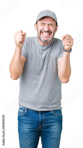 Handsome middle age hoary senior man wearing sport cap over isolated background excited for success with arms raised celebrating victory smiling. Winner concept.