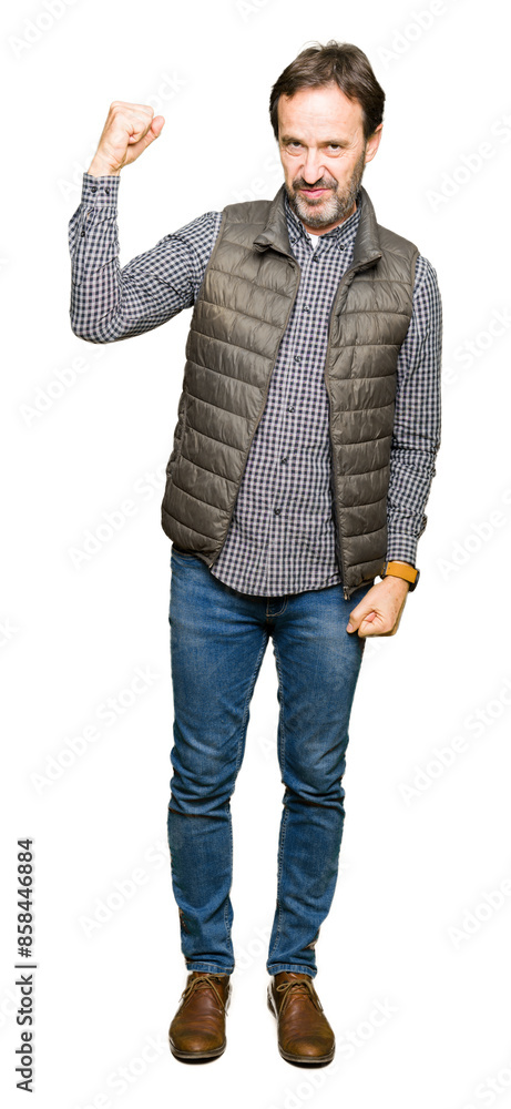 Middle age handsome man wearing winter vest Strong person showing arm muscle, confident and proud of power Middle age handsome man wearing winter vest Strong person showing arm muscle, confident and proud of power