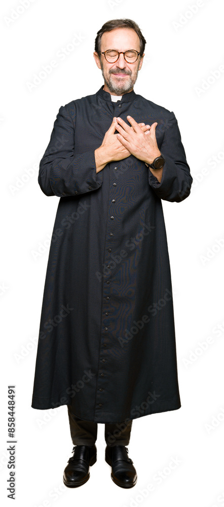 Middle age priest man wearing catholic robe smiling with hands on chest with closed eyes and grateful gesture on face. Health concept. Middle age priest man wearing catholic robe smiling with hands on chest with closed eyes and grateful gesture on face. Health concept.