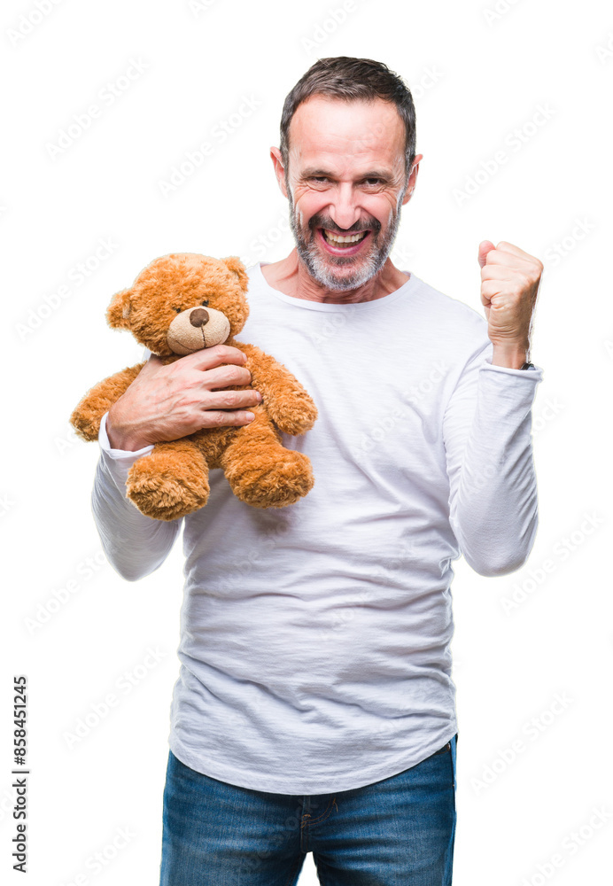 Middle age senior hoary man holding teddy bear over isolated background screaming proud and celebrating victory and success very excited, cheering emotion Middle age senior hoary man holding teddy bear over isolated background screaming proud and celebrating victory and success very excited, cheering emotion