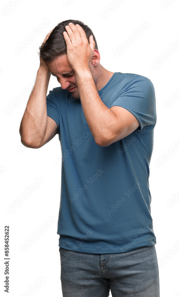 Handsome young casual man suffering from headache desperate and stressed because pain and migraine. Hands on head. Handsome young casual man suffering from headache desperate and stressed because pain and migraine. Hands on head.