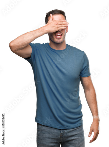 Handsome young casual man smiling and laughing with hand on face covering eyes for surprise. Blind concept.