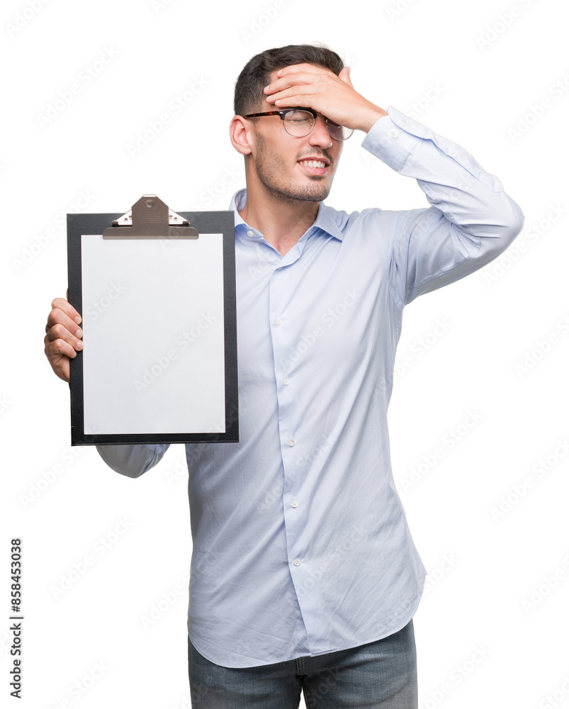 Handsome young business man showing a clipboard stressed with hand on head, shocked with shame and surprise face, angry and frustrated. Fear and upset for mistake. Handsome young business man showing a clipboard stressed with hand on head, shocked with shame and surprise face, angry and frustrated. Fear and upset for mistake.
