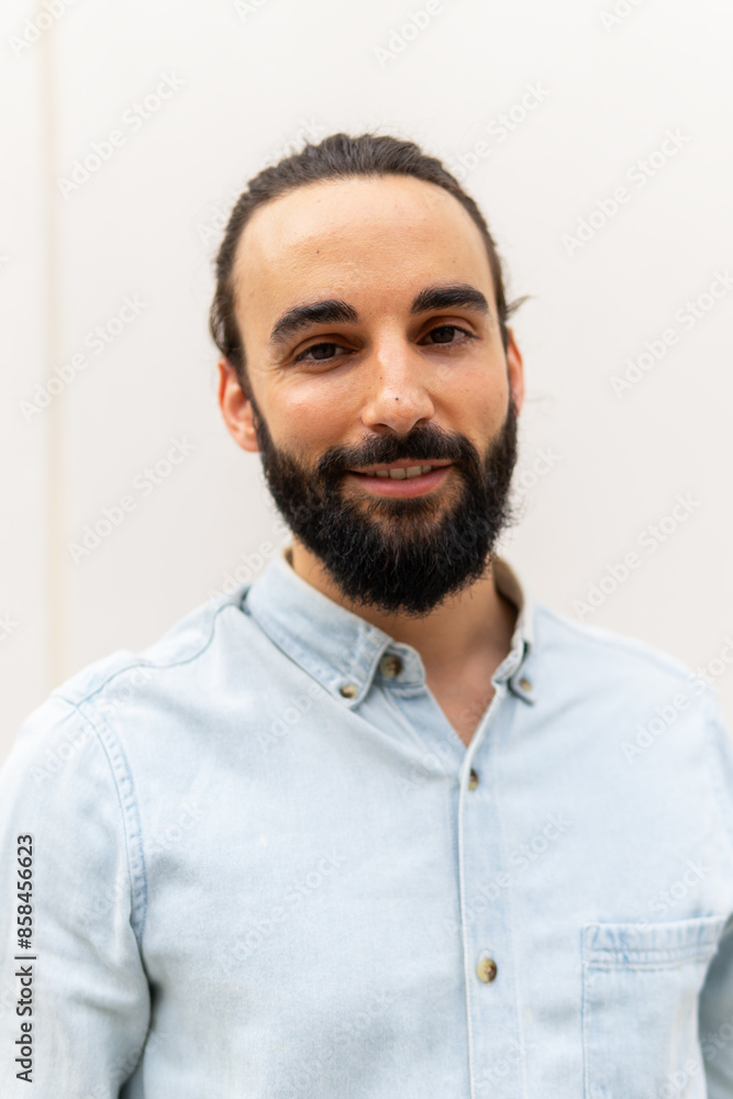 Portrait of a smiling man in a blue shirt with a full beard Portrait of a smiling man in a blue shirt with a full beard