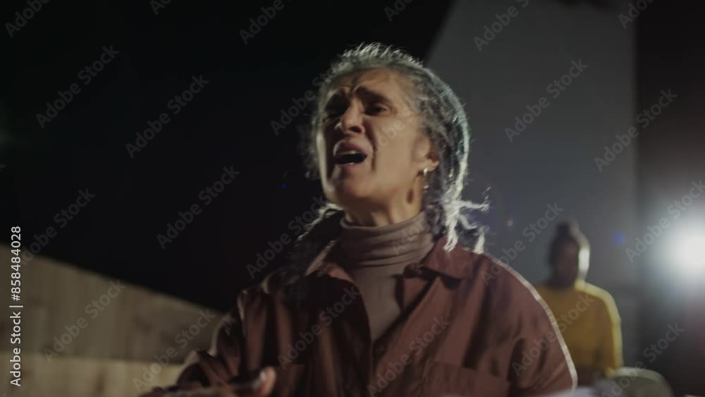 Senior actress holding paper script and showing emotional performance on stage during rehearsal in theatre Senior actress holding paper script and showing emotional performance on stage during rehearsal in theatre