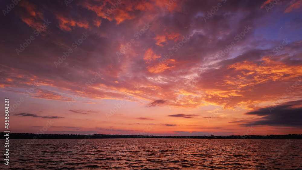 Obraz premium sunset over a tranquil lake with rippled water, sky with soft clouds