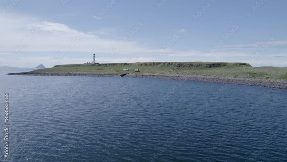 Drone flying over a scenic Isle of Arran Lighthouse with blue skies and clouds, documentaries about Scotland. Drone flying over a scenic Isle of Arran Lighthouse with blue skies and clouds, documentaries about Scotland.