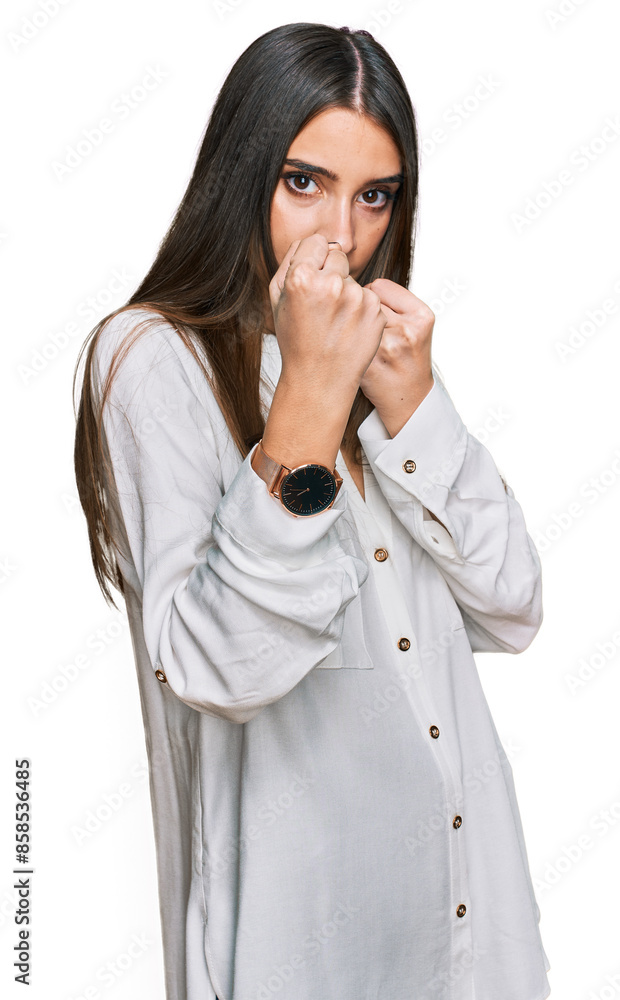 Young beautiful woman wearing casual white shirt ready to fight with fist defense gesture, angry and upset face, afraid of problem Young beautiful woman wearing casual white shirt ready to fight with fist defense gesture, angry and upset face, afraid of problem