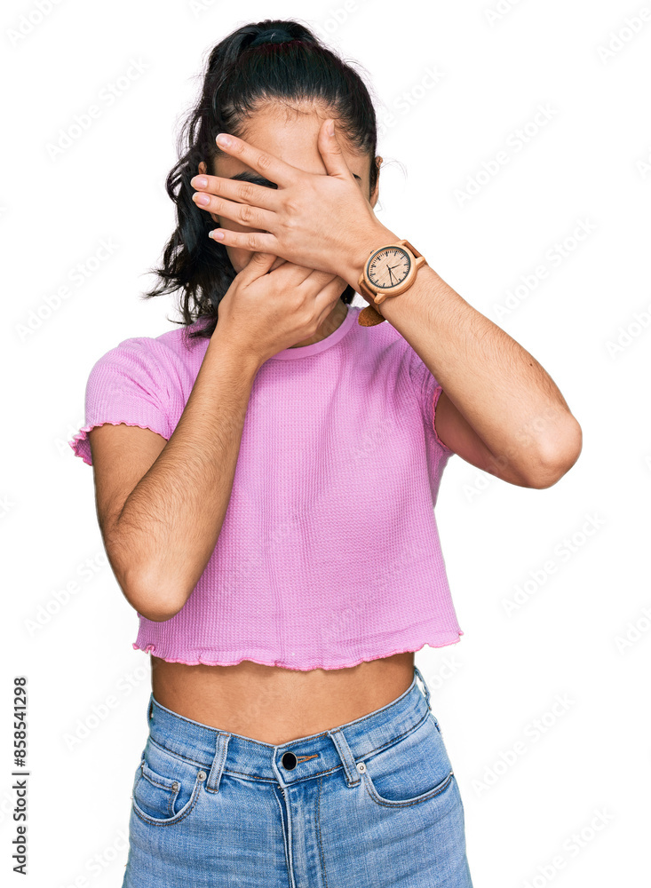 © Krakenimages.com - Hispanic teenager girl with dental braces wearing casual clothes covering eyes and mouth with hands, surprised and shocked. hiding emotion