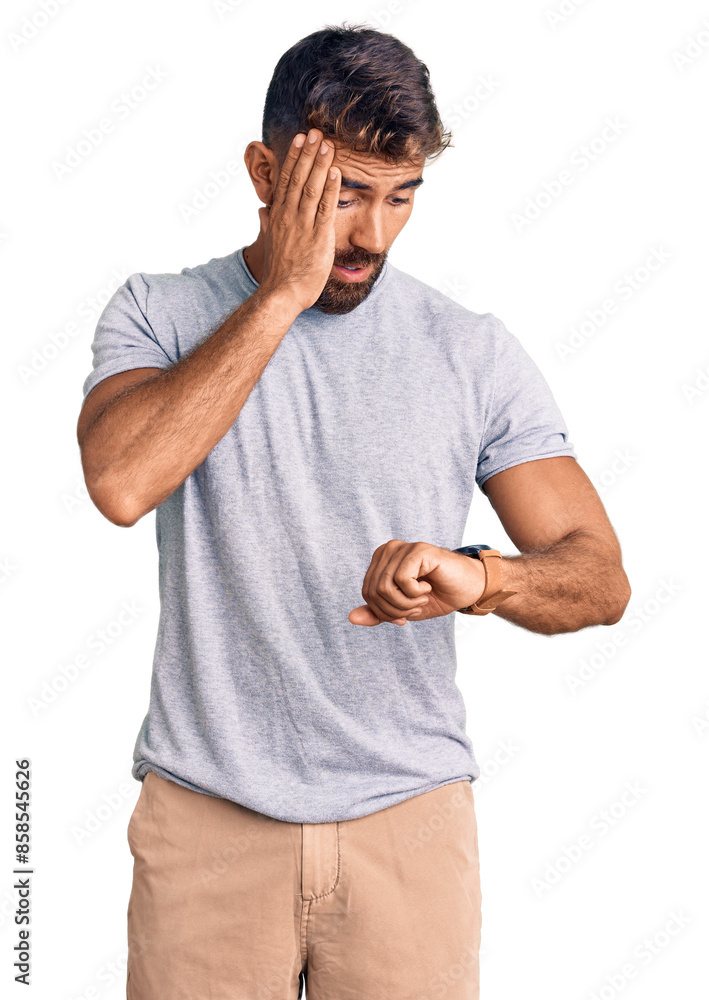 Young hispanic man wearing casual clothes looking at the watch time worried, afraid of getting late Young hispanic man wearing casual clothes looking at the watch time worried, afraid of getting late