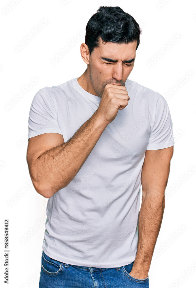 Handsome hispanic man wearing casual white t shirt feeling unwell and coughing as symptom for cold or bronchitis. health care concept. Handsome hispanic man wearing casual white t shirt feeling unwell and coughing as symptom for cold or bronchitis. health care concept.