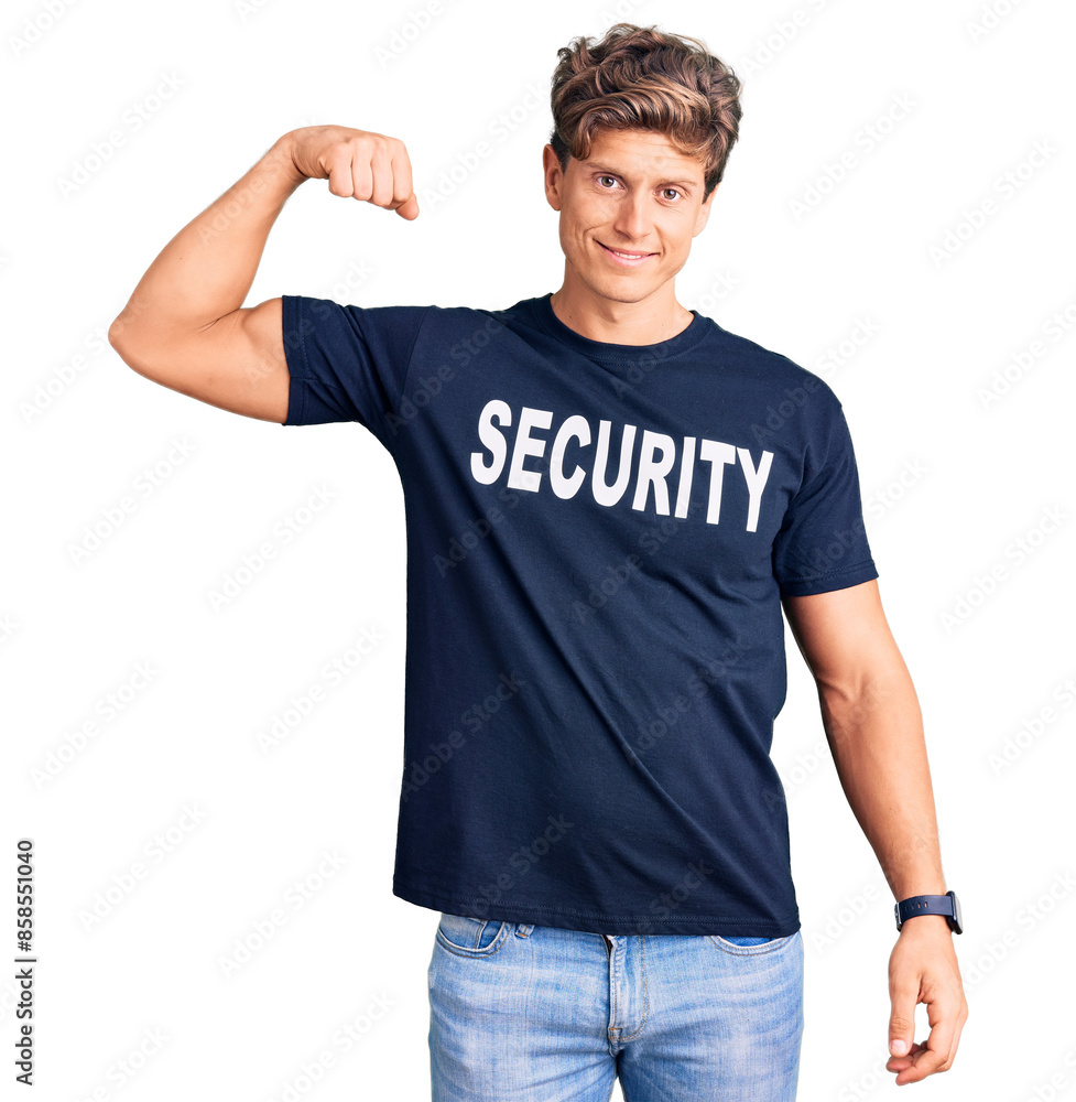 Young handsome man wearing security t shirt strong person showing arm muscle, confident and proud of power Young handsome man wearing security t shirt strong person showing arm muscle, confident and proud of power
