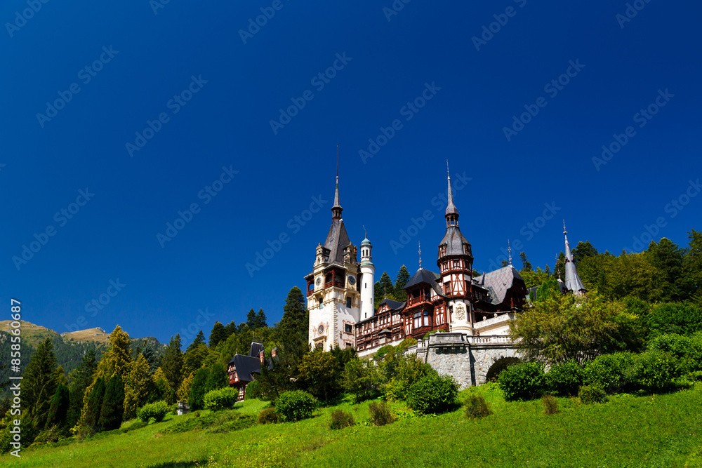 The Peles castle in the town of Sinaia, Transylvania, Carpathian Mountains, Romania, Summer time, bright sunny day with dark blue sky. The Peles castle is the most impressive castle in Romania The Peles castle in the town of Sinaia, Transylvania, Carpathian Mountains, Romania, Summer time, bright sunny day with dark blue sky. The Peles castle is the most impressive castle in Romania