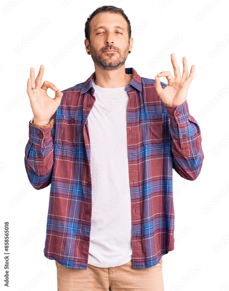 Young handsome man wearing casual clothes relaxed and smiling with eyes closed doing meditation gesture with fingers. yoga concept. Young handsome man wearing casual clothes relaxed and smiling with eyes closed doing meditation gesture with fingers. yoga concept.