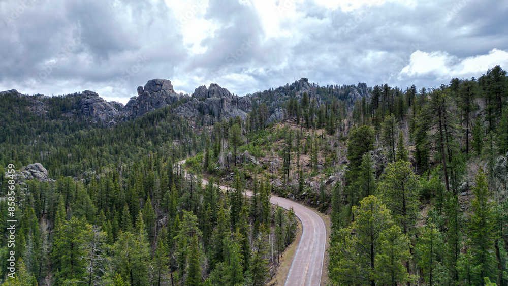 Winding road in rocky mountains. Drone shot, aerial photo of highway goes through the national park. Forest landscape Winding road in rocky mountains. Drone shot, aerial photo of highway goes through the national park. Forest landscape