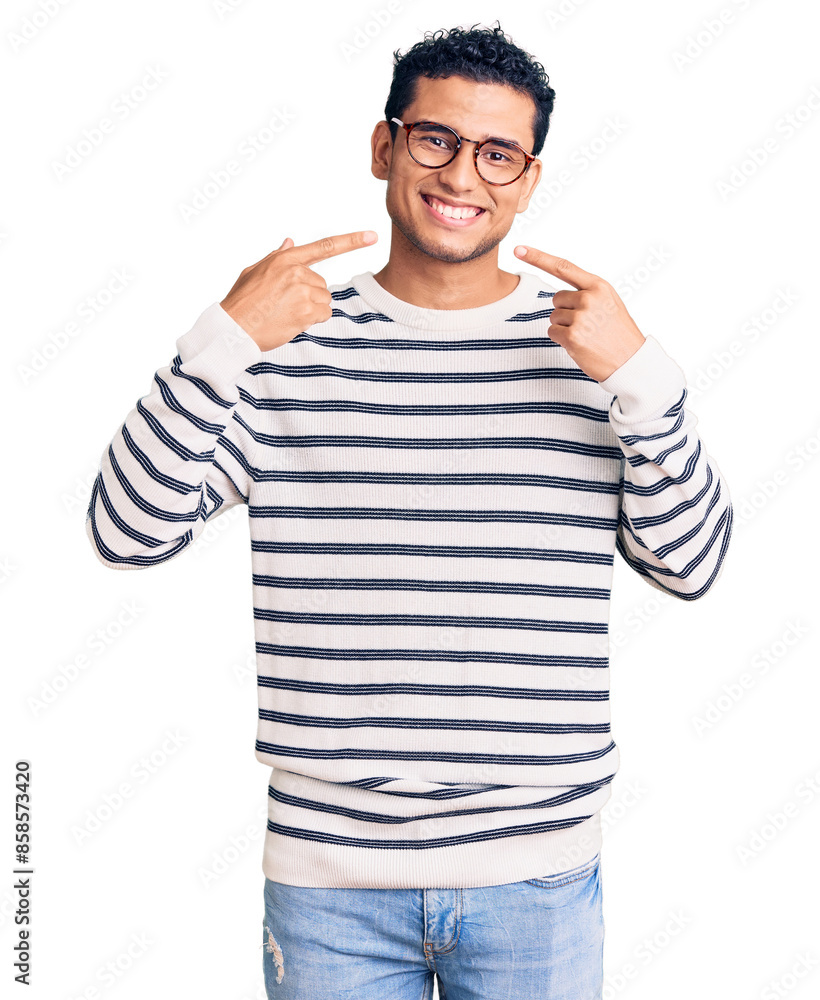 Hispanic handsome young man wearing casual clothes and glasses smiling cheerful showing and pointing with fingers teeth and mouth. dental health concept. Hispanic handsome young man wearing casual clothes and glasses smiling cheerful showing and pointing with fingers teeth and mouth. dental health concept.