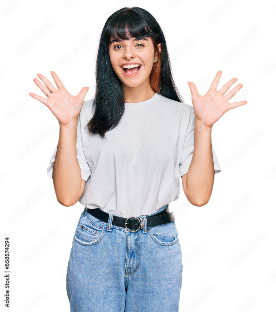 Young hispanic girl wearing casual clothes celebrating crazy and amazed for success with arms raised and open eyes screaming excited. winner concept Young hispanic girl wearing casual clothes celebrating crazy and amazed for success with arms raised and open eyes screaming excited. winner concept