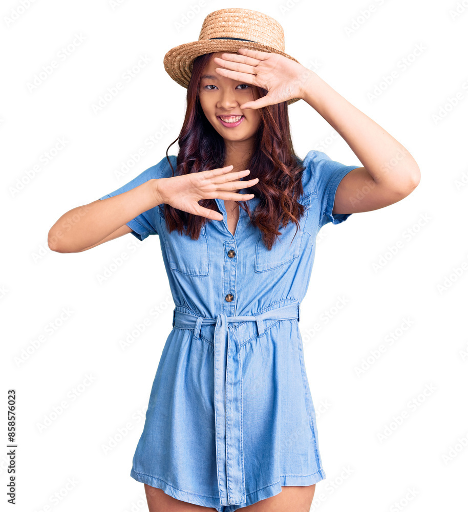 Young beautiful chinese girl wearing summer hat smiling cheerful playing peek a boo with hands showing face. surprised and exited Young beautiful chinese girl wearing summer hat smiling cheerful playing peek a boo with hands showing face. surprised and exited