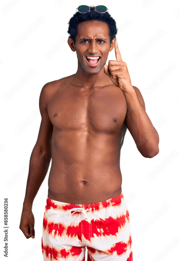 Obraz na plátně African handsome man wearing swimsuit and sunglasses pointing finger up with successful idea