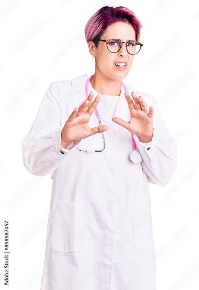 Foto Young beautiful woman with pink hair wearing doctor uniform disgusted expression, displeased and fearful doing disgust face because aversion reaction