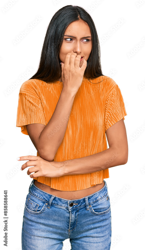 Young brunette arab woman wearing casual clothes looking stressed and nervous with hands on mouth biting nails. anxiety problem. Young brunette arab woman wearing casual clothes looking stressed and nervous with hands on mouth biting nails. anxiety problem.