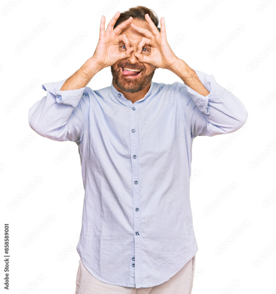 Handsome middle age man wearing business shirt doing ok gesture like binoculars sticking tongue out, eyes looking through fingers. crazy expression. Handsome middle age man wearing business shirt doing ok gesture like binoculars sticking tongue out, eyes looking through fingers. crazy expression.