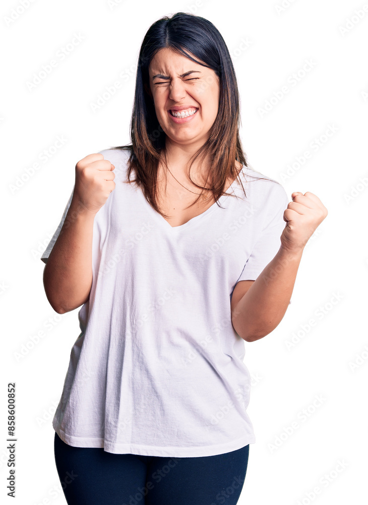 Young beautiful brunette woman wearing casual t-shirt very happy and excited doing winner gesture with arms raised, smiling and screaming for success. celebration concept. Young beautiful brunette woman wearing casual t-shirt very happy and excited doing winner gesture with arms raised, smiling and screaming for success. celebration concept.
