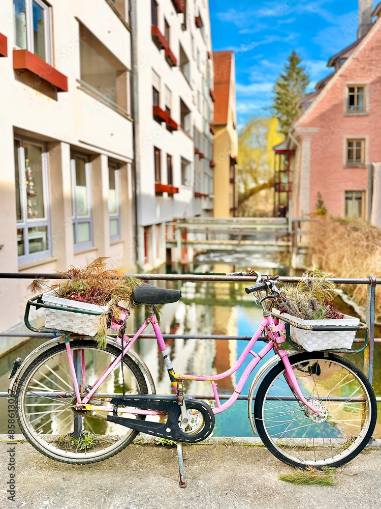 Fototapeta premium Pink Bicycle Standing In Front Of Beautiful Ulm Cityscape Reflection, Germany