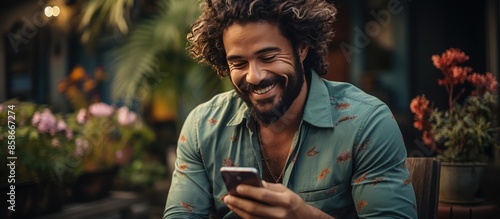 portrait of a handsome man checking social media while using a smartphone and airpods in the yard