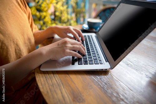 A woman is typing on a laptop at a table