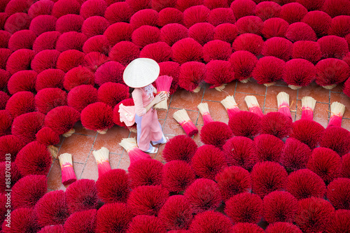 Asian women wear traditional white Vietnamese culture and Incense sticks drying outdoor wearing conical hat photo