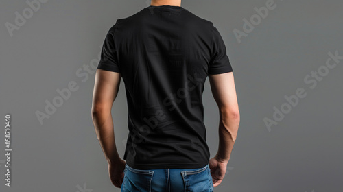 Mockup black T-shirt on a back strong man in blue jeans. on a gray background. Template ready for your design