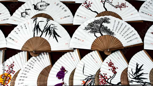 KOREA, SEOUL – April 2024: painted hand fan with various asian drawing isolated on white paper, Seoul, South Korea