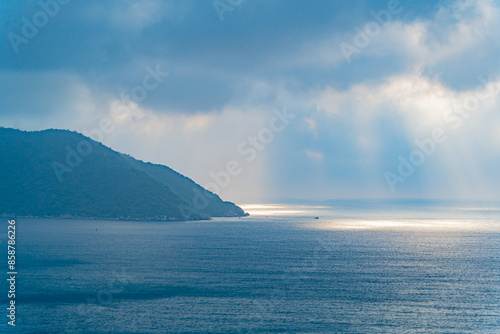 The rays of the sun through the clouds over the sea. A natural phenomenon over an island in the sea. Vietnam, the South China Sea. 