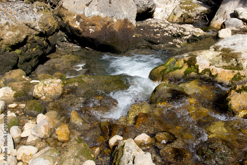 Shallow riverbed with exposed rocky bottom, lack of flow and water flow, in autumn in nature Shallow riverbed with exposed rocky bottom, lack of flow and water flow, in autumn in nature