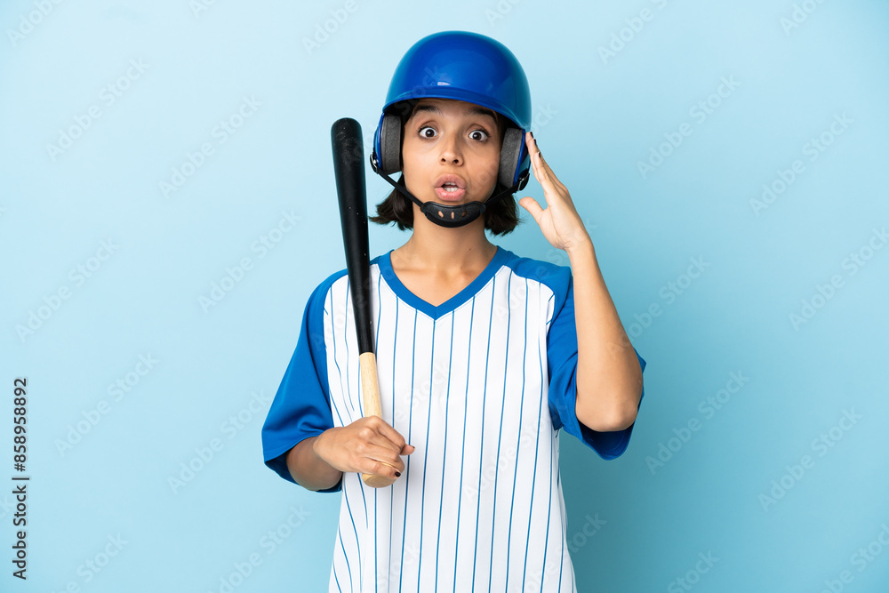 Baseball mixed race player woman with helmet and bat isolated on blue background with surprise expression Baseball mixed race player woman with helmet and bat isolated on blue background with surprise expression