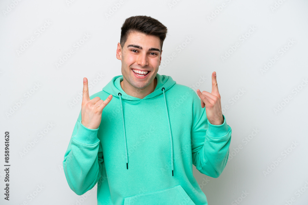 Young caucasian man isolated on white background making horn gesture Young caucasian man isolated on white background making horn gesture