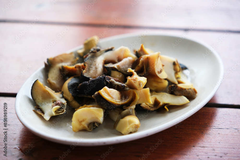 a plate of Sea snail meat on table a plate of Sea snail meat on table
