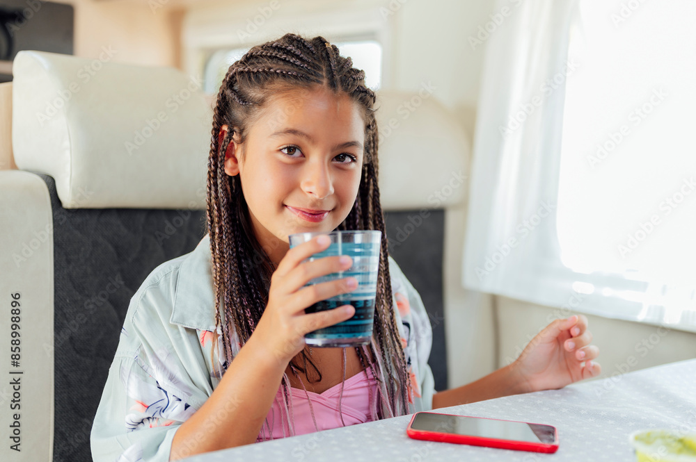 Caucasian cute girl with long hair is holding a water glass in her hands Caucasian cute girl with long hair is holding a water glass in her hands