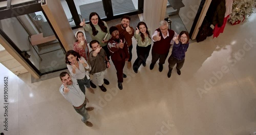 An overhead view captures a diverse group of employees gathering in a sleek corporate foyer, conveying a sense of collaboration and corporate culture, showcasing a diverse and inclusive workplace.