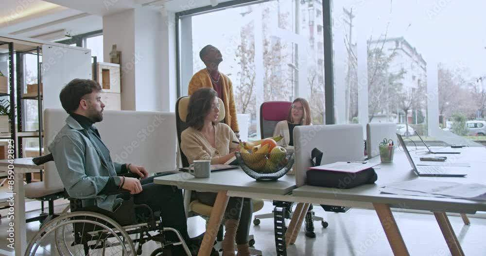 A diverse team of workers, including a person in a wheelchair, engaged in discussion at a well-lit, spacious office environment, exemplifying teamwork and inclusivity. A diverse team of workers, including a person in a wheelchair, engaged in discussion at a well-lit, spacious office environment, exemplifying teamwork and inclusivity.