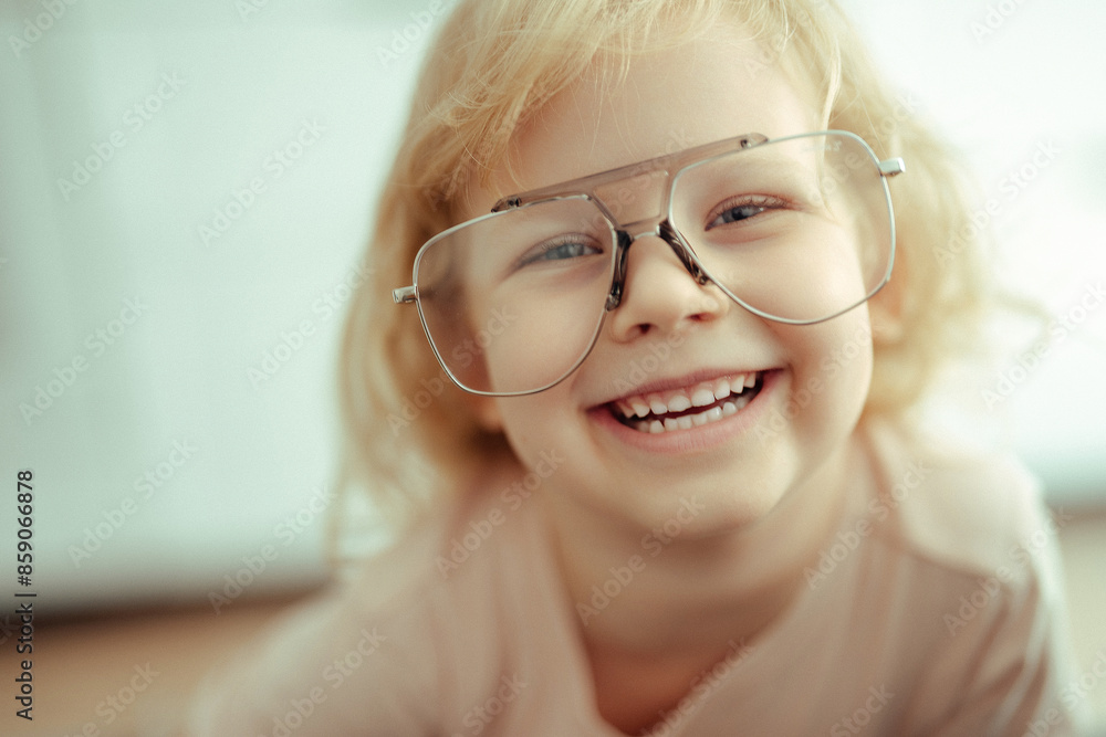 beautiful cute child girl blonde with curly hair in large stylish glasses smiling. beautiful cute child girl blonde with curly hair in large stylish glasses smiling.