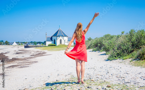 Penvins chapel in sarzeau-Morbihan, brittany in France- Woman tourist in red dress on the beach photo