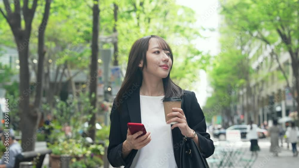 スマホを持って街を歩く女性ビジネスパーソン スマホを持って街を歩く女性ビジネスパーソン