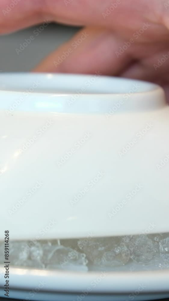 Pieces of crushed ice on a white plate, lift the lid and look into cold cocktail plate Pieces of crushed ice on a white plate, lift the lid and look into cold cocktail plate